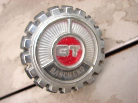 1973 Ford Ranchero - A close-up shot shows a chrome emblem with a red center that reads "GT" above the word "RANCHERO" in black lettering.