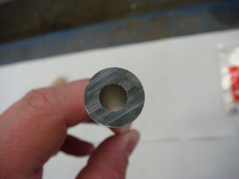 1996 Ford Bronco - Photograph of the end of a hollow metal tube held by hand, not a technical document.