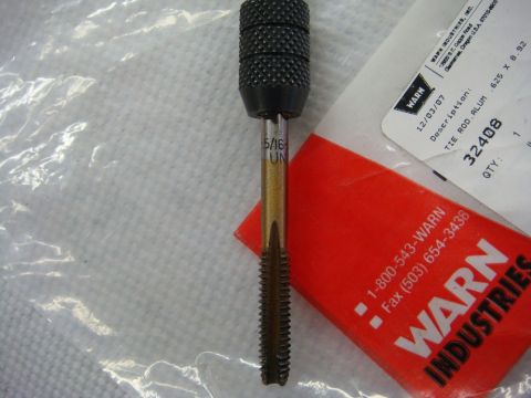 1996 Ford Bronco - Photograph of a thread tap resting on a Warn parts package, not a technical document.