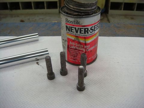 1996 Ford Bronco - Photograph of fasteners and rods next to an anti-seize lubricant can, not a technical document.