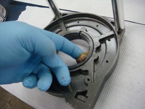 1996 Ford Bronco - Photograph of a winch housing being greased during assembly, not a technical document.