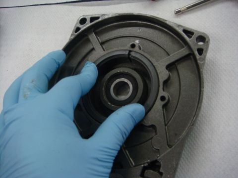 1996 Ford Bronco - Workshop photo of a winch end-cap housing and bearing being handled, not a technical document.