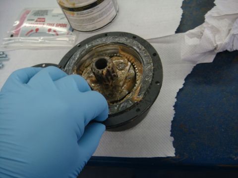 1996 Ford Bronco - Workshop photo of a winch end housing being handled, not a technical document.