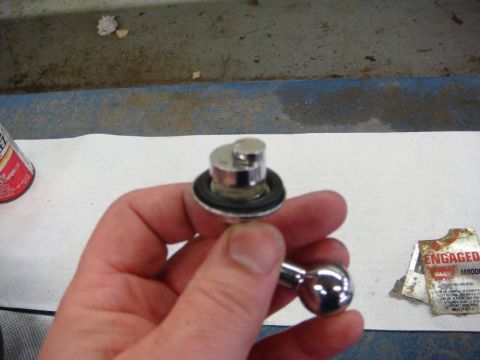 1996 Ford Bronco - A close-up view of a hand holding a small, intricate metal component, likely an automotive part.