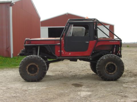 1992 Ford Bronco - This heavily modified Jeep Wrangler sits outside a rural building, its off-road capabilities.
