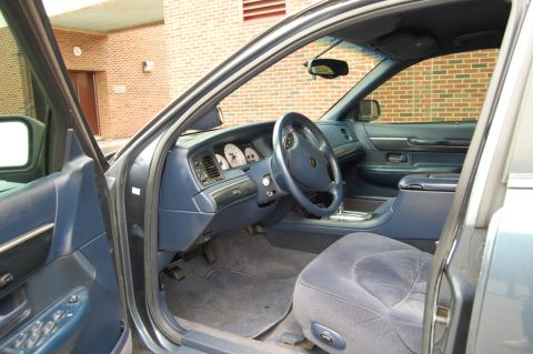 1985 Mercury Grand Marquis - The interior of a blue sedan is shown, plush seats and a clear dashboard.