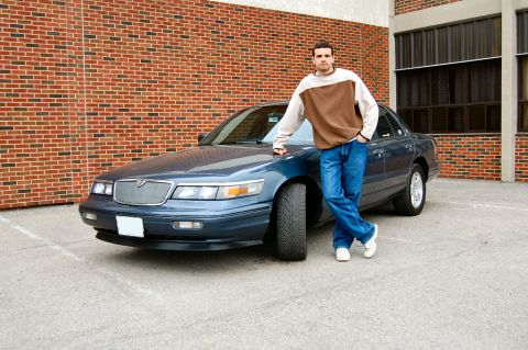 1985 Mercury Grand Marquis - A man poses with a blue sedan, which appears to be from the early 2000s.