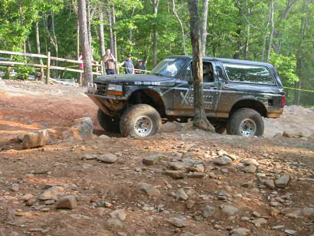 1990 Ford Bronco navigating rocky terrain on an off-road trail