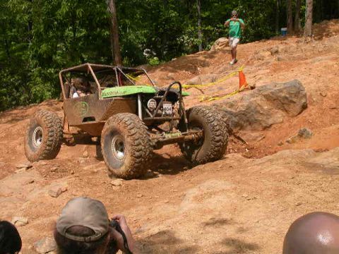 1990 Ford Bronco - This custom buggy is tackling a challenging off-road course with steep inclines and large rocks.