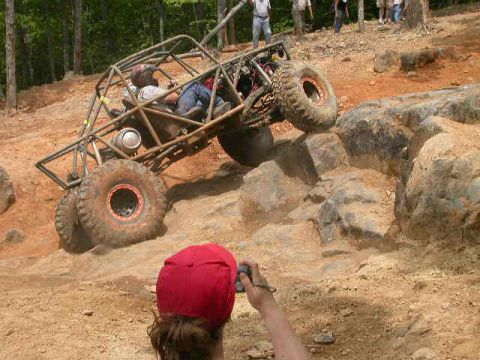 1990 Ford Bronco - A custom-built off-road buggy navigates a challenging rocky terrain during an event.