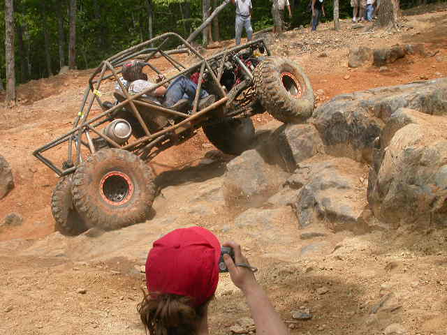 Off-road buggy with roll cage climbing large rocks