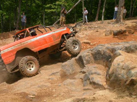 1990 Ford Bronco - Off-road vehicle navigates a challenging rocky terrain during an event.