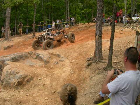 1990 Ford Bronco - An off-road buggy navigates a steep, rocky incline during a race event.