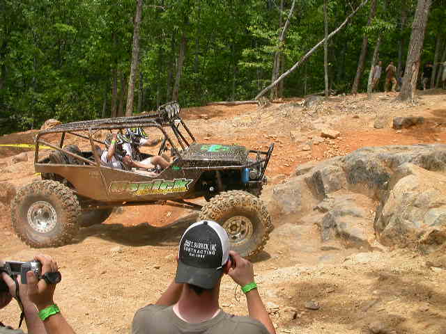 Off-road buggy with roll cage navigating rocky terrain