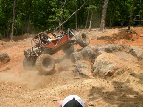 1990 Ford Bronco - A custom off-road buggy navigates a challenging rocky terrain during a race event.