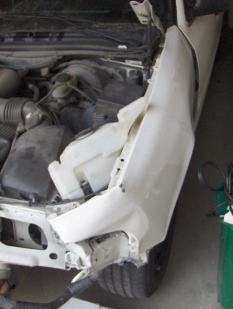 2003 Ford Crown Victoria - The front end of a car has sustained significant damage, revealing the engine components.