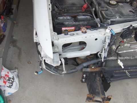 2003 Ford Crown Victoria - Front end of a 2003 Ford Crown Victoria disassembled, revealing the battery and wiring harness.