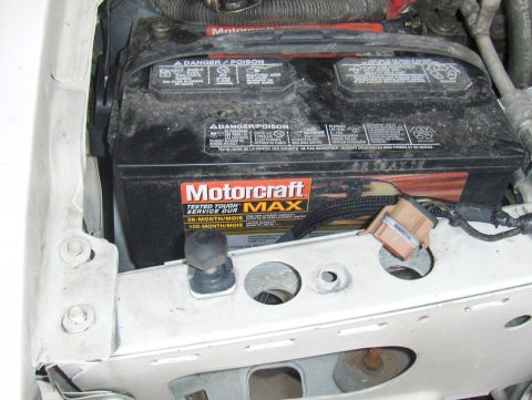 2003 Ford Crown Victoria - A close-up view of a Motorcraft car battery under the hood of a vehicle.