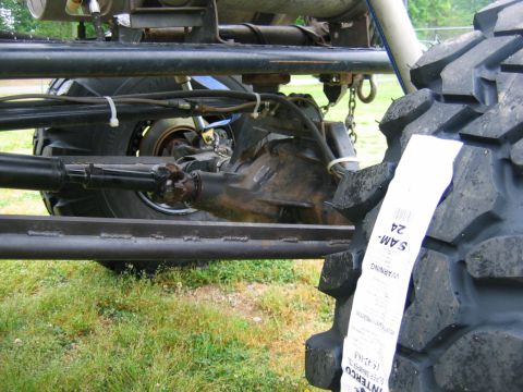 1992 Ford Mustang - The drivetrain components and a new tire are visible on this off-road vehicle.
