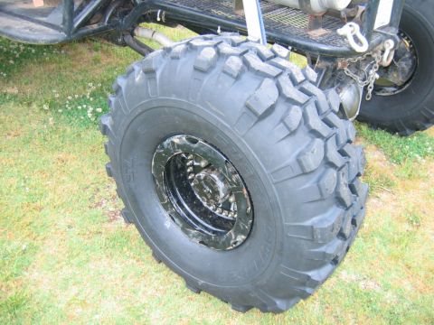 1992 Ford Mustang - Close-up of a large, knobby tire and suspension components on a custom off-road vehicle.