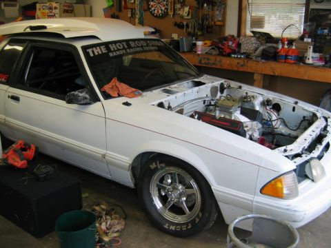 1992 Ford Mustang - White 1992 Ford Mustang in garage with engine bay open. "THE HOT ROD SHOP" sticker visible on windshield.