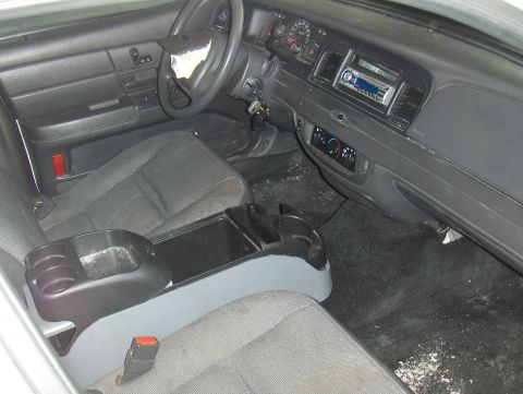 2003 Ford Crown Victoria - The interior of a 2003 Ford Crown Victoria is visible, including the dashboard and seats.