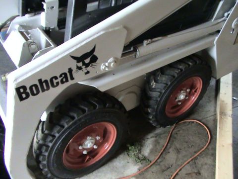 1946 Ford F1 - Close-up of a Bobcat skid steer loader, showing its distinctive logo and tires.