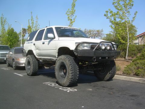 1993 Toyota 4Runner - A heavily modified 1993 Toyota 4Runner is shown with large tires and a custom front bumper.