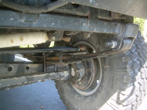 1993 Toyota 4Runner - Undercarriage view of a vehicle's suspension system, focusing on the leaf springs and tire.