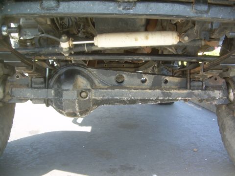 1993 Toyota 4Runner - The underside of a vehicle shows its rear axle, leaf springs, and a shock absorber.
