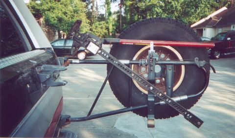 1990 Ford Bronco - Spare tire carrier with a hi-lift jack mounted on the rear of an SUV.