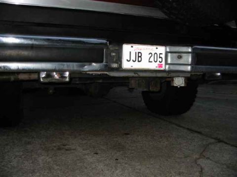 1990 Ford Bronco - The rear of a vehicle is shown, including the bumper, license plate, and a tire.