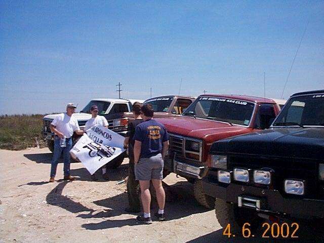 1990 Ford Bronco club members holding a banner with a Bronco graphic