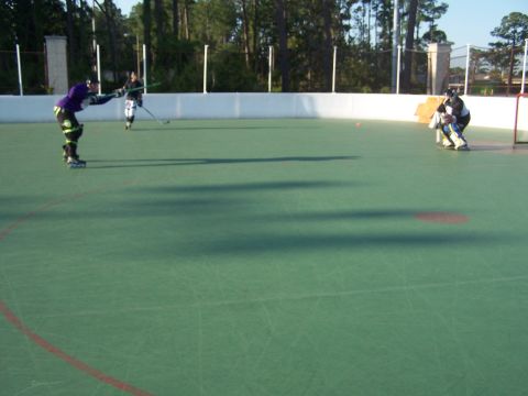 1973 Ford Ranchero - Outdoor roller hockey game in progress on a green court with players in action.