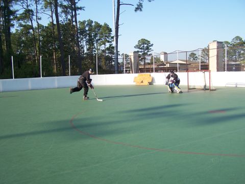 1973 Ford Ranchero - Outdoor roller hockey game in progress with players on skates and a goalie.