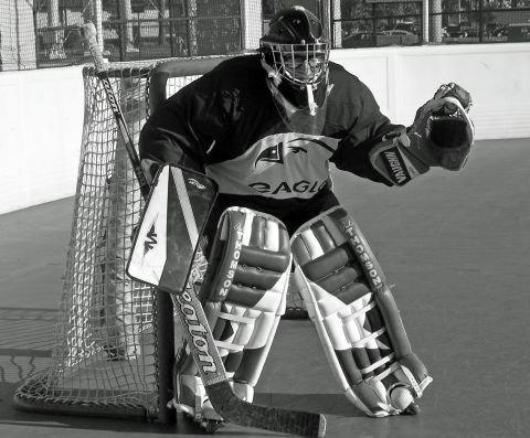 1973 Ford Ranchero - A goalie in protective equipment is positioned in front of a hockey net.