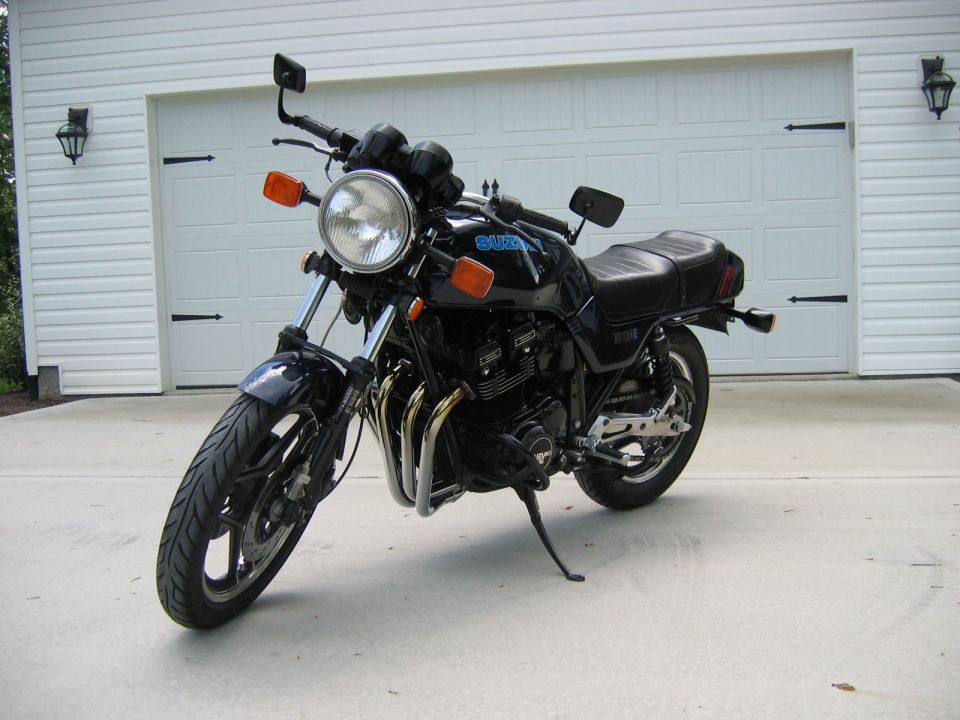 Black Suzuki motorcycle parked in front of a white garage door