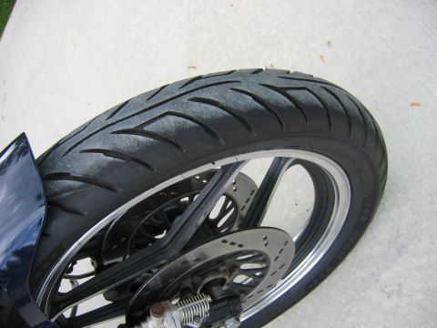 1985 Ford LTD Crown Victoria - Photograph of a motorcycle rear wheel and tire, not a technical document.