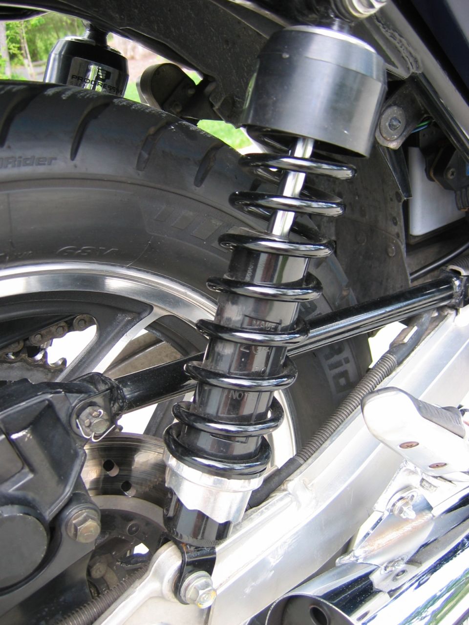 Close-up of a motorcycle rear coil-over shock absorber and swingarm