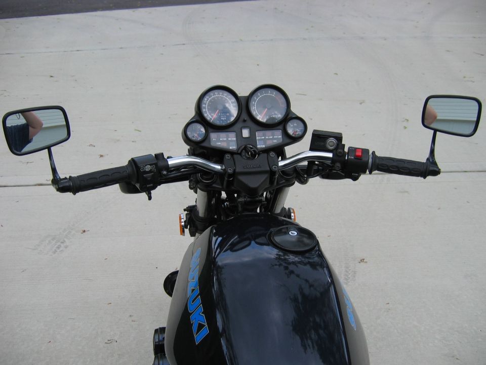 Rider's-eye view of a motorcycle handlebar, gauges and fuel tank