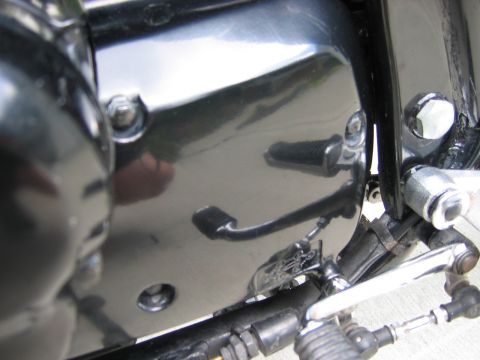 1985 Ford LTD Crown Victoria - Detail shot of a motorcycle's engine casing and controls, including a foot peg and shift linkage.