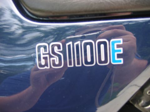 1985 Ford LTD Crown Victoria - The side of a blue motorcycle displays the 'GS1100E' model designation.