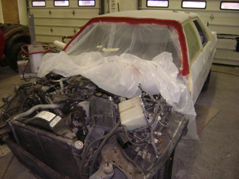 2001 Ford Crown Victoria - Car in garage with engine exposed and body covered in plastic for repair work.