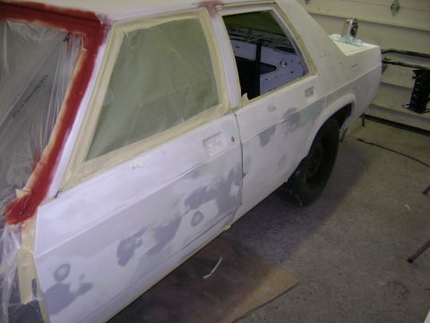 2001 Ford Crown Victoria - A car body is shown in profile, masked and primed, indicating it is in the process of being painted or repaired.