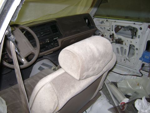 2001 Ford Crown Victoria - The interior of a car shows the dashboard, steering wheel, and seats, with the door panel removed.
