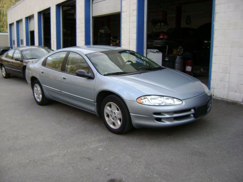 2001 Ford Crown Victoria - A silver sedan is parked in front of a garage with another car behind it.