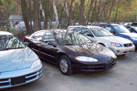 2001 Ford Crown Victoria - Several cars parked in a lot, including a dark purple Dodge Intrepid and a silver vehicle.