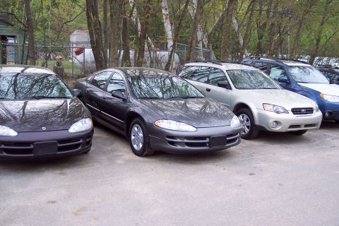 2001 Ford Crown Victoria - Several cars parked in a lot, with a Dodge Intrepid in the foreground.