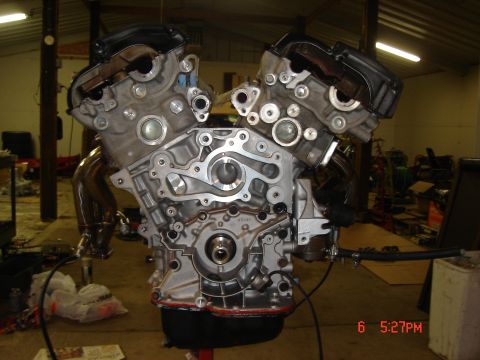 1993 Ford Probe - This V-engine block is shown disassembled in a workshop setting, with various components and tools in the background.
