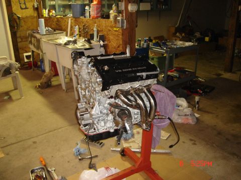 1993 Ford Probe - A V6 DOHC engine is mounted on a red stand in a garage, ready for installation or repair.
